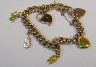 A 9ct gold curb link charm bracelet with padlock clasp, hung 5 charms