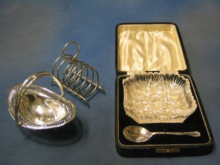 A cut glass preserve jar (slight chip) with spoon, cased and a 5 bar silver plated toast rack a pierced boat shaped silver plated dish with swing handle 7"