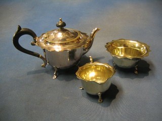 A circular 1930's  3 piece silver plated tea service with teapot, cream jug and sugar bowl with wavy edge, on hoof feet
