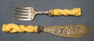 A handsome pair of Victorian pierced silver fish servers with carved ivory handles in the form of dolphins Sheffield 1873