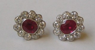 A pair of lady's gold ear studs set rubies surrounded by 10 diamonds (approx 0.90ct)