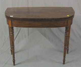 A 19th Century mahogany D shaped card table with ebony stringing, raised on turned supports 36"