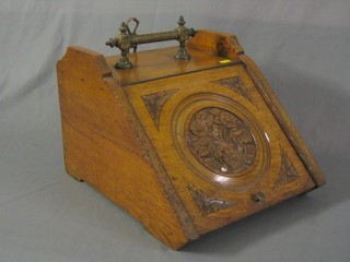 A Victorian carved honey oak coal box with hinged lid  14"