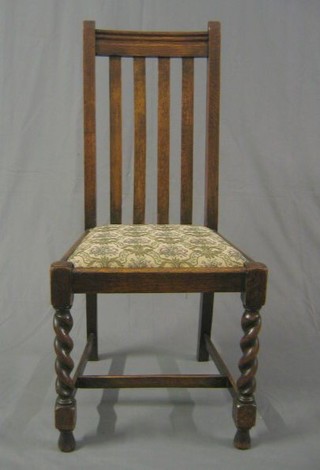 A set of 4 1930's oak stick and rail back dining chairs with upholstered drop in seats on spiral turned supports