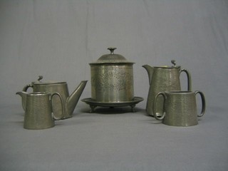 A Victorian circular engraved pewter biscuit barrel with hinged lid  and  a planished English pewter 4 piece tea service