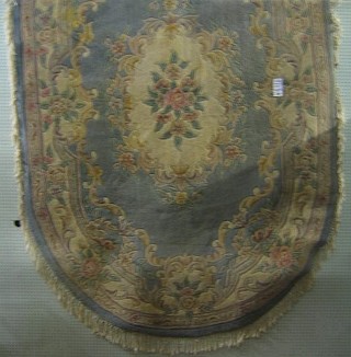 A contemporary oval machine made Chinese carpet with blue and floral ground 107" x 71"