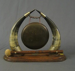 A tea gong raised on 2 buffalo horns with oak base and beater