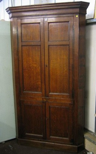 An 18th/19th Century Country honey oak double corner cabinet enclosed by panelled doors 52"