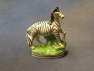 A 19th Century Staffordshire figure of a Zebra raised on an oval naturalistic base 6" (f and r)