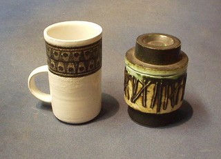 A circular Troica mug 4 1/2" mug and a Troica style jar and cover 4" (2)