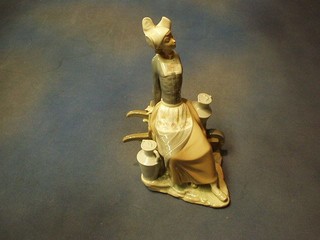 A Lladro figure of a seated Dutch girl on wheelbarrow, the base incised 9 14"