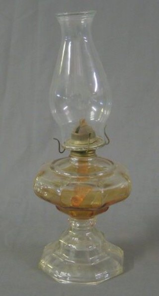 An octagonal glass oil lamp reservoir with clear glass chimney