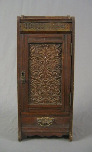A 19th Century oak smoker's cabinet enclosed by carved panelled door 9"
