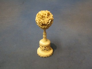 A carved ivory puzzle ball and stand 7"