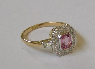 A lady's 18ct yellow gold dress ring set a rectangular pink cut sapphire surrounded by diamonds and with diamonds to the shoulders (0.41/0.77ct)