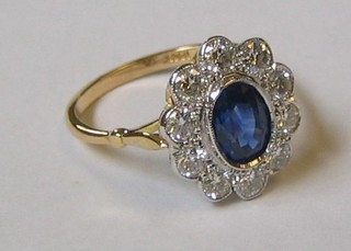 A lady's 18ct yellow gold dress ring set an oval cut sapphire surrounded by 10 diamonds (approx 1.0ct/1.50ct)