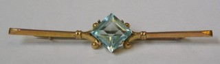A lady's gold bar brooch set a diamond cut blue stone (loose)