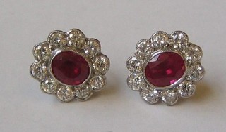 A pair of lady's gold ear studs set rubies surrounded by 10 diamonds (approx 0.90ct)
