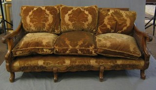 A 1930's carved walnutwood double cane 3 piece bergere suite comprising 3 seat settee and 2 armchairs, carved throughout and raised on cabriole supports 