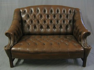 A Georgian style mahogany framed sofa upholstered in brown buttoned back hide 54"