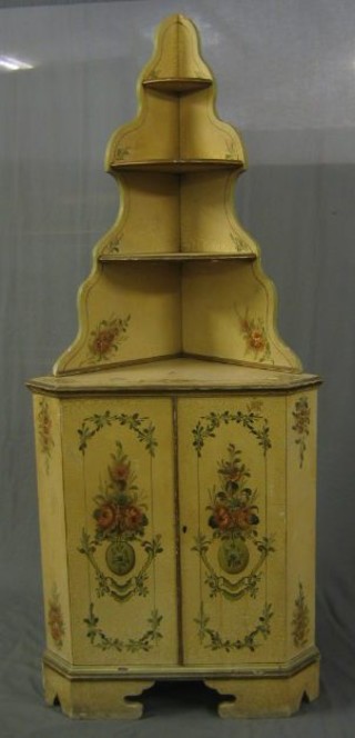A Continental painted corner cabinet with raised stepped back, the base fitted a cupboard enclosed by a panelled door and raised on bracket feet 22" 275-350