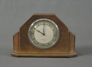 An Art Deco 8 day bedroom timepiece with silvered dial and Arabic numerals by W Batty & Sons of Manchester contained in a bleached oak case