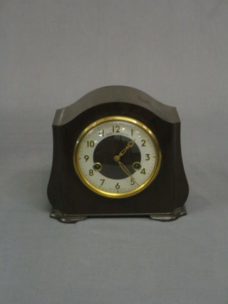 A 1930's 8 day striking mantel clock with silvered dial contained in an arched brown Bakelite case
