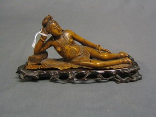 An Eastern carved wooden figure of a reclining lady on a pierced stand 7"