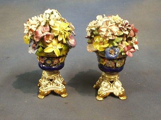A pair of 19th Century Derby porcelain urns with floral encrusted decoration, blue bodies and gilt feet, the base with Derby mark (1830-1848) 7" (some damage to flowers)