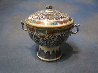 An Oriental porcelain twin handled circular pedestal jar and cover, the interior with detachable bowl 7"