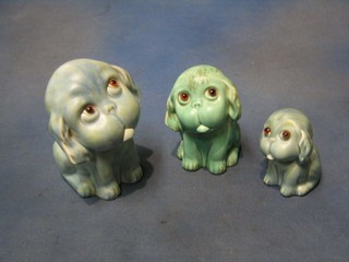 3 graduated Crown Devon green glazed pottery dogs with glass eyes marked 10145