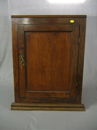 A 19th Century oak hanging corner cabinet fitted shelves and enclosed by panelled doors 21"