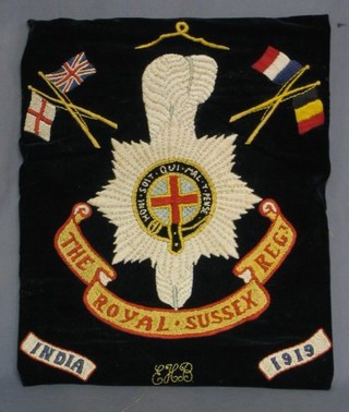 A wool work panel depicting the crest of the Royal Sussex Regt. dated 1919, 18" x 15" 
