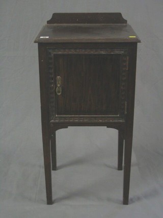 An Edwardian mahogany pot cupboard enclosed by a panelled door on square tapering supports 16"