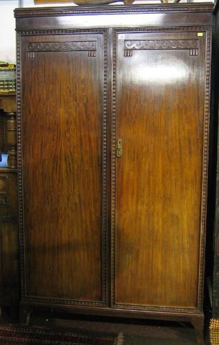 A mahogany wardrobe enclosed by panelled doors, raised on splayed bracket feet 41"