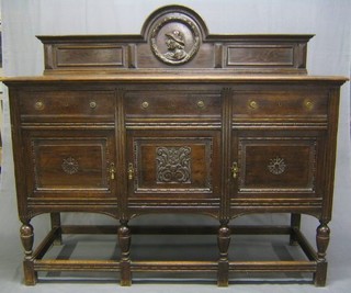 A carved oak Jacobean style sideboard with raised back and carved head and shoulders portrait of a gentleman, the base fitted 3 long drawers above a triple cupboard, raised on turned and block supports 60"