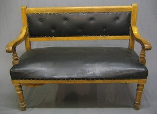A Victorian bleached mahogany open arm "snooker" observing settle, with upholstered seat and back, raised on turned supports 48"