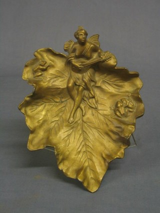 A gilt spelter dish in the form of a leaf with lady playing mandolin 10"