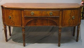 A handsome Georgian mahogany sideboard, fitted 2 short drawers flanked by a double cupboard and a drawer, raised on turned and reeded supports 71"