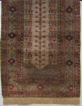 A 19th/20th Century machine made rug with blue ground and Tree of Life motif to the middle within multi-row borders 71" x 47"
