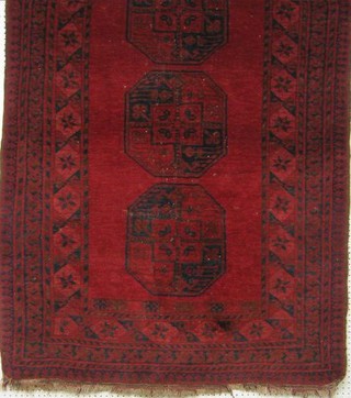 An Afghan rug with 3 octagons to the centre within multi-row border 71" x 45"