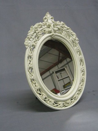 An oval plate mirror contained in a pierced resin frame