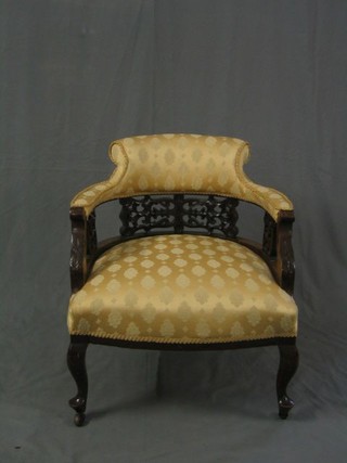 A pair of Victorian carved mahogany tub back chairs upholstered in yellow material, on cabriole supports