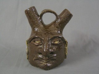 An 18th/19th Century pottery double spouted flask in the form of a grotesque, 8"