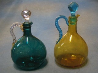 A 19th Century green glass ewer and stopper with clear  glass handle 9" (f and r) and a 19th Century amber glass ewer  with blue glass handle and stopper (chip to rim) 10"
