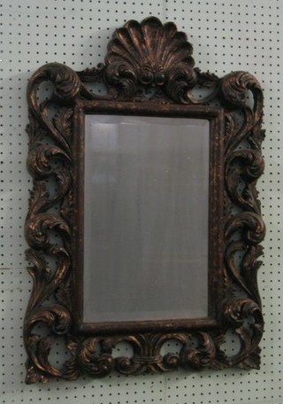 A rectangular Rococo style bevelled plate wall mirror contained in a pierced gilt  frame surmounted by a scallop shell 31" 