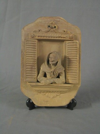 A 19th Century Italian terracotta plaque in the form a lady leaning out of a shuttered open window 11"