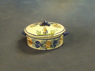 A circular twin handled Quimper butter dish and cover, the lid decorated a lady, the base and lid marked Henriot Quimper France 4"