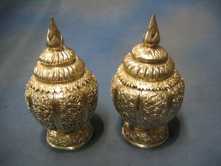 A pair of circular Eastern embossed silver urns and covers 10" 26 ozs