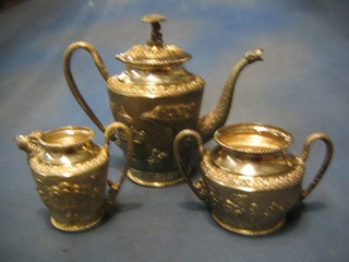 A handsome Eastern embossed 3 piece silver tea service decorated court figures, elephants, attendants etc, comprising teapot, twin handled sugar bowl and cream jug 48 ozs
